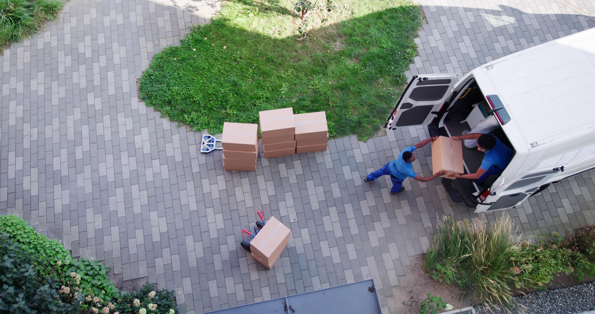 High Angle View Of Delivery Men Unloading The Cardboard Boxes