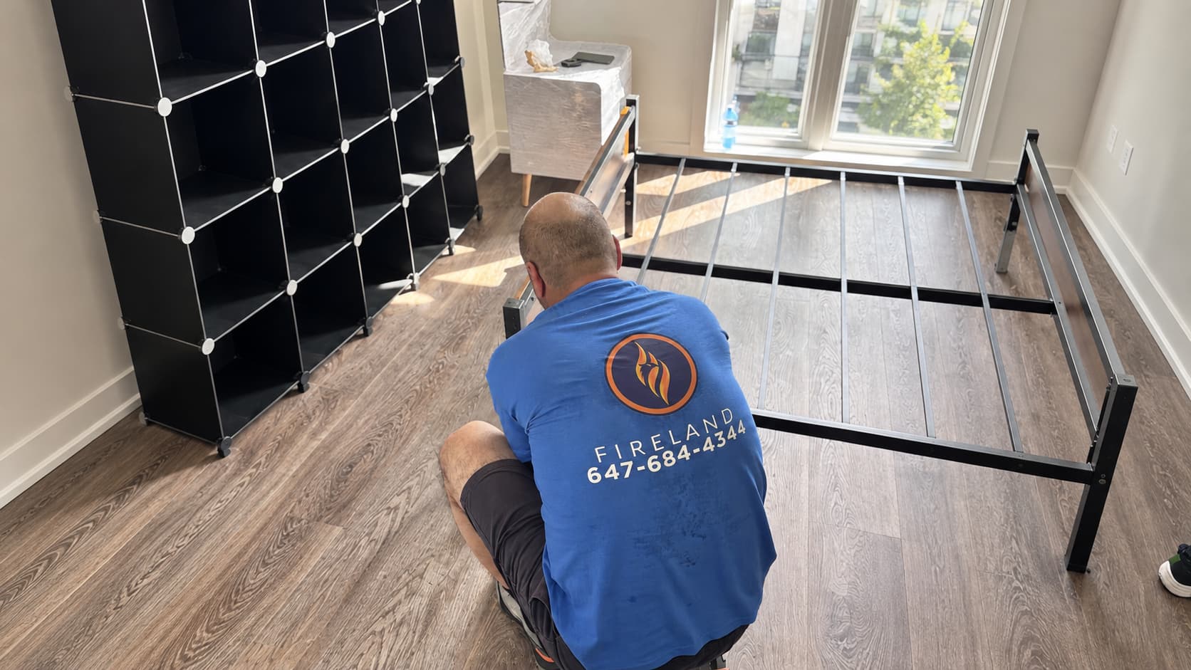 Fireland mover assembling a metal bed frame in a bedroom