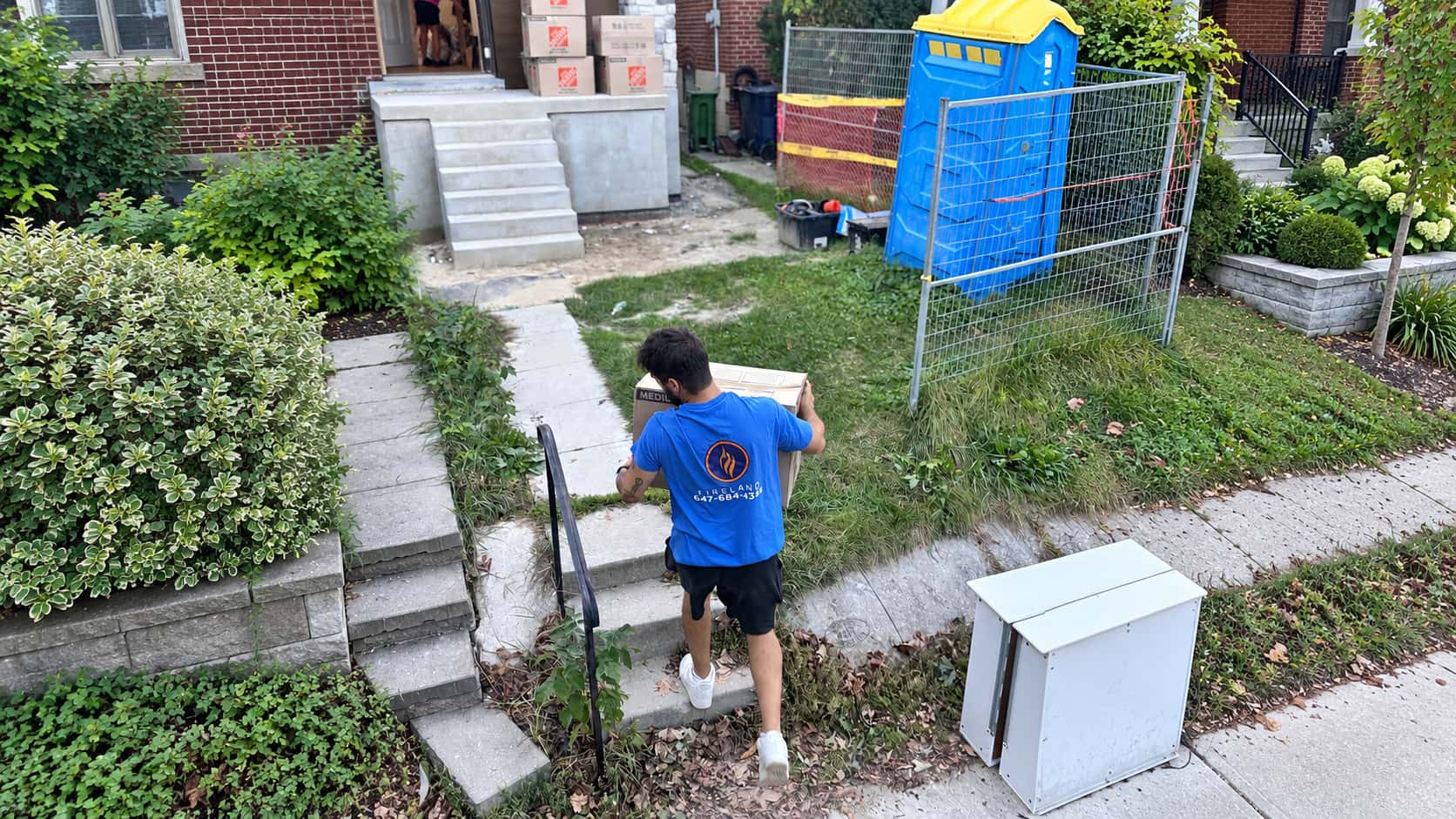 Fireland mover carrying items up the front garden steps of a home